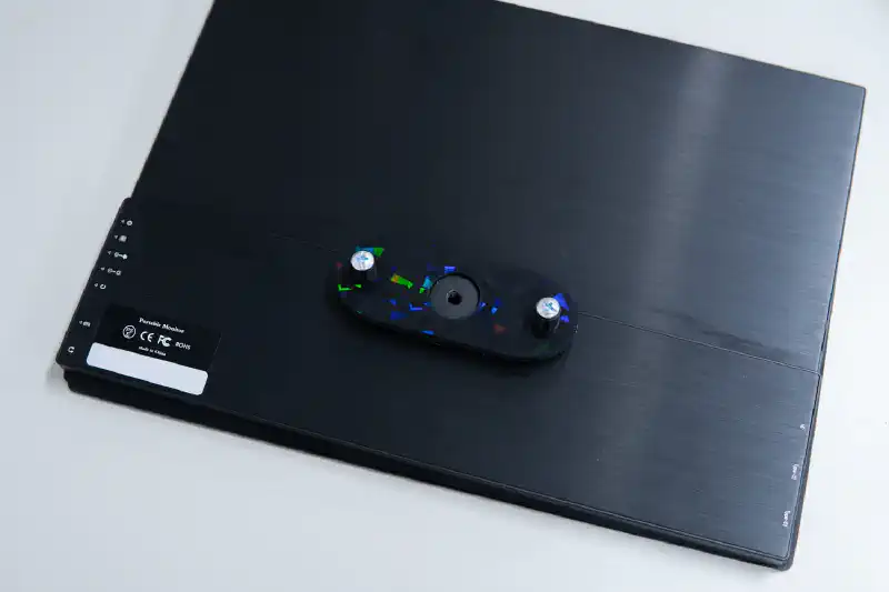 モニターに自作アダプタを装着した様子。中央に金属製の三脚穴が追加された。